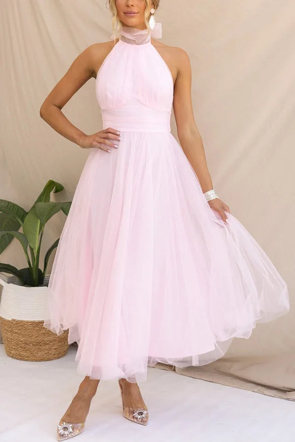 Model in a dark pink tulle halter midi dress showcasing the silhouette and skirt volume