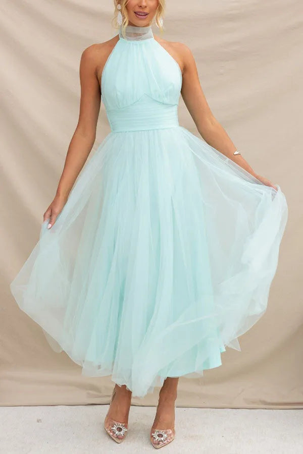 Model in a three-quarter turn wearing a light blue tulle halter midi dress