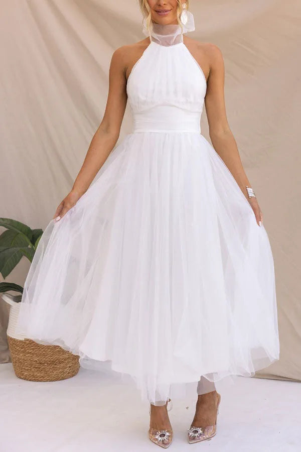 Model wearing a white tulle halter midi dress with layered skirt