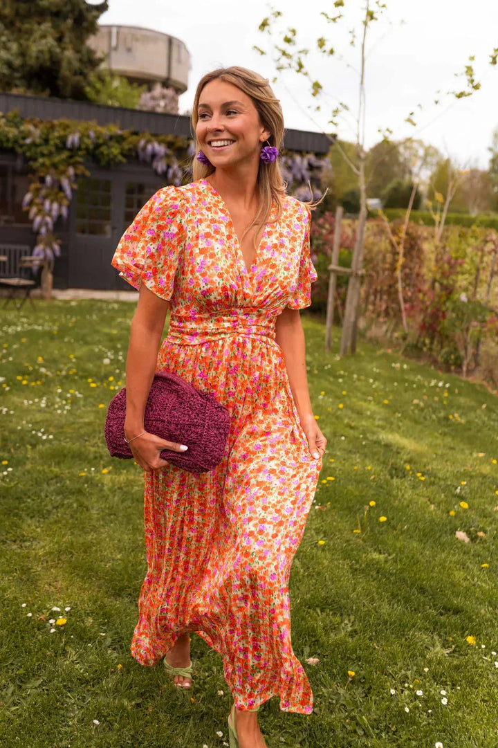 Close-up detail of orange flutter sleeve maxi dress showing fabric texture and sleeve design
