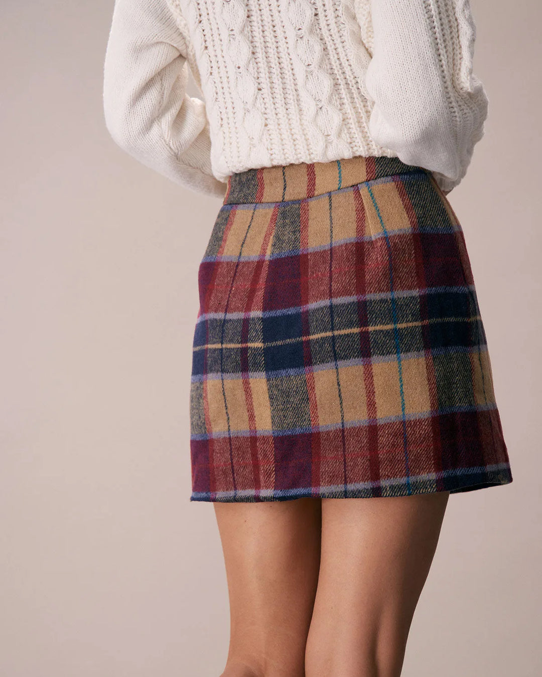 Model in side profile wearing a red plaid mini skirt