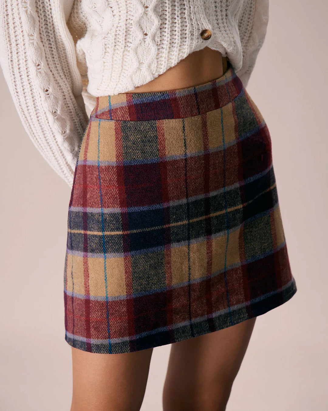 Model at three-quarter turn wearing a red plaid mini skirt