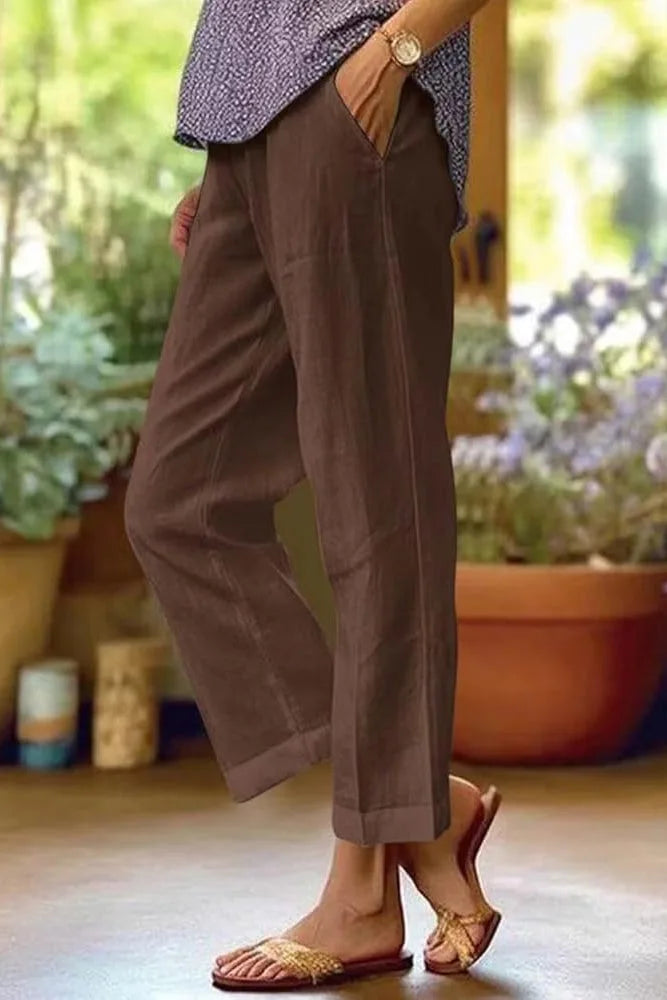 Brown cuffed cropped pants on a model in a three-quarter turn pose