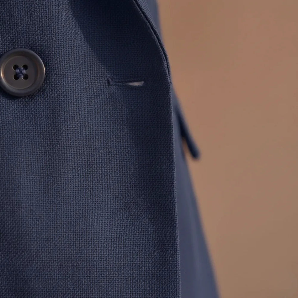 Close-up detail of navy double-breasted blazer buttons and lapel
