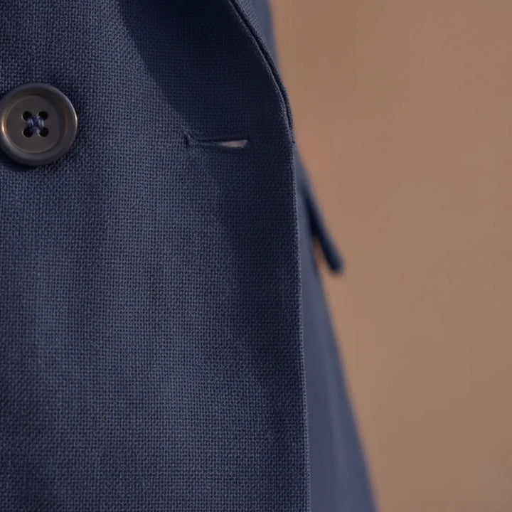 Close-up detail of navy double-breasted blazer buttons and lapel