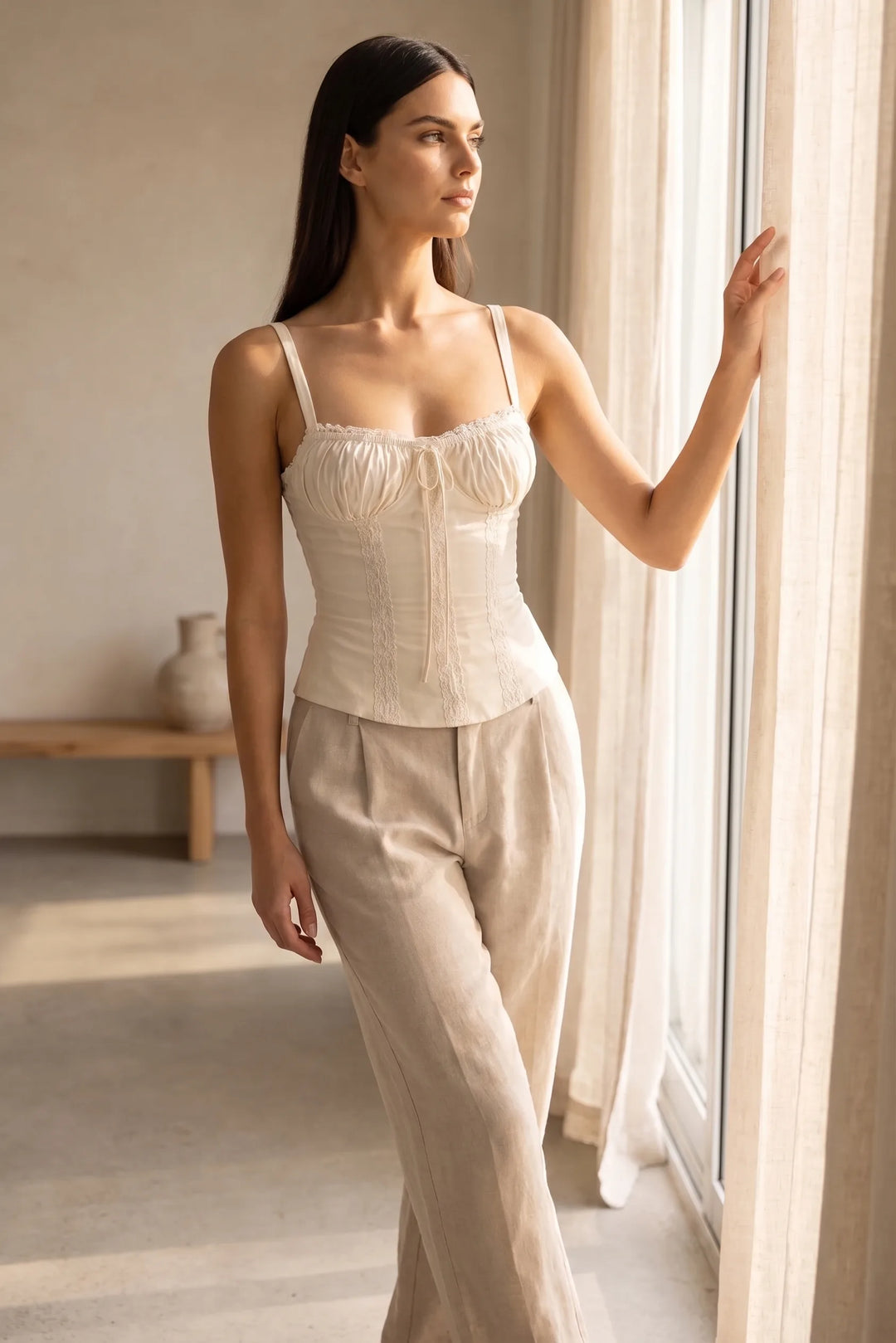 Model wearing a white lace trim corset cami in a lifestyle setting