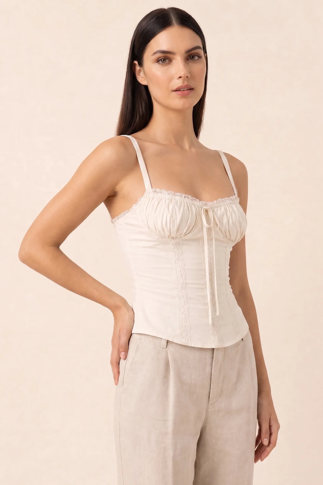 White lace trim corset cami on a model in a three-quarter turn pose