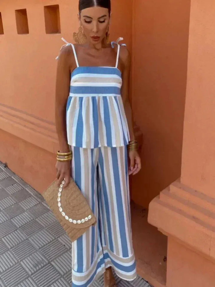 Woman facing forward in a blue striped peplum top and matching skirt set