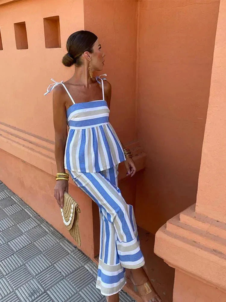 Side view of a woman in a blue striped peplum top and coordinating skirt