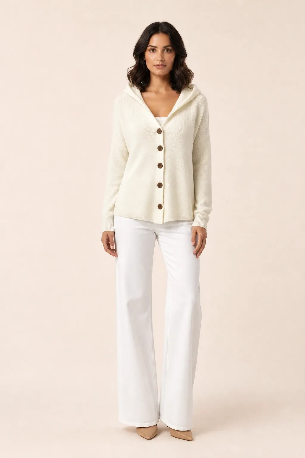 Beige hooded button cardigan on a model in a contrapposto stance