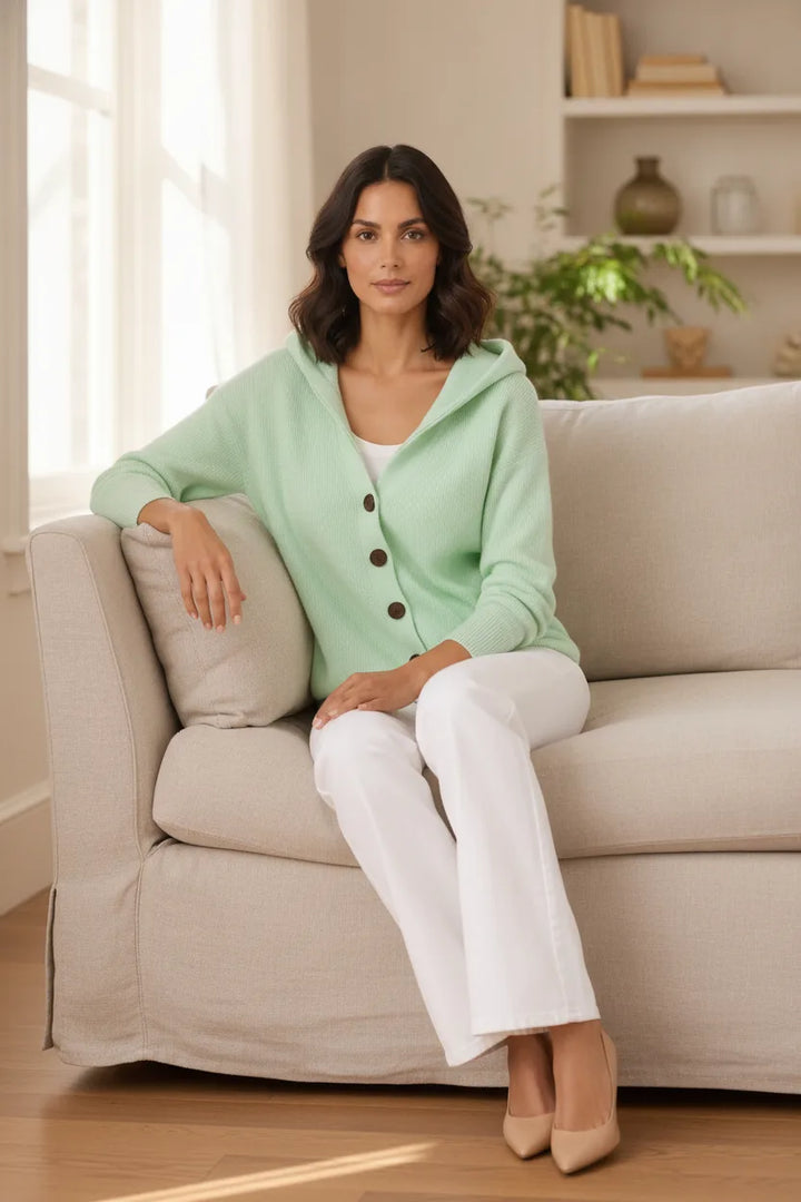 Green hooded button cardigan displayed outside a storefront