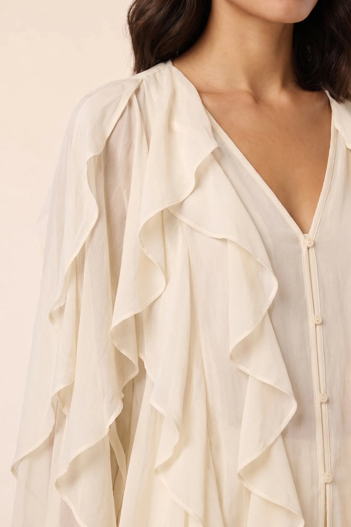 Close-up detail of yellow cascading ruffle blouse fabric and layers