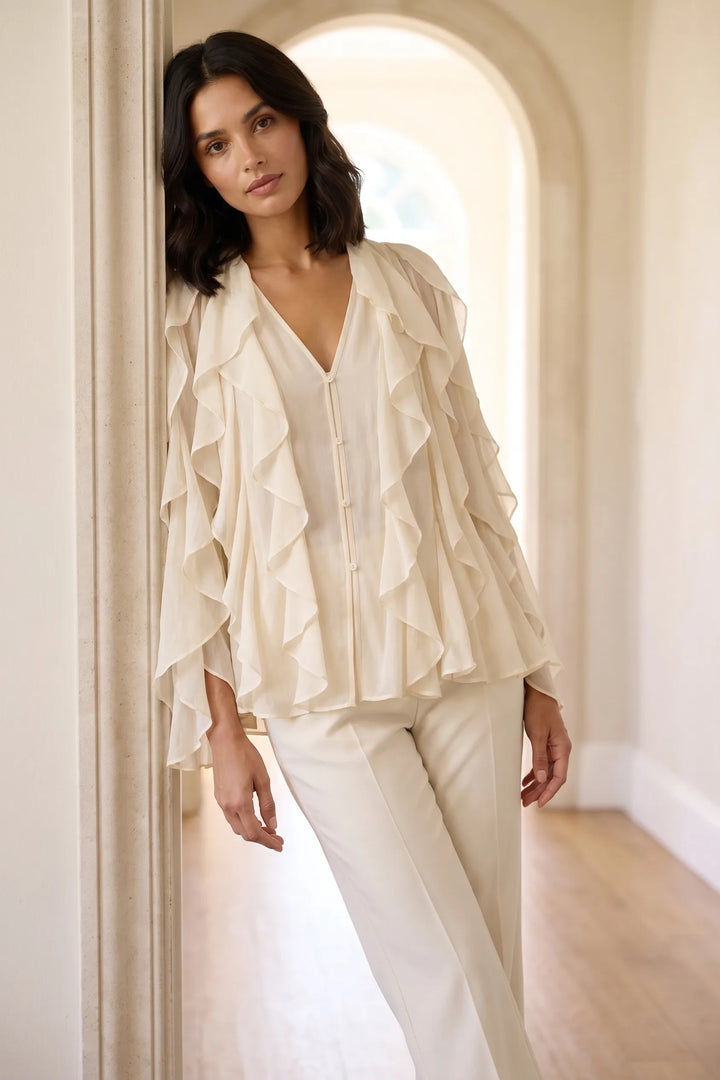 Model wearing a yellow cascading ruffle blouse in a lifestyle setting