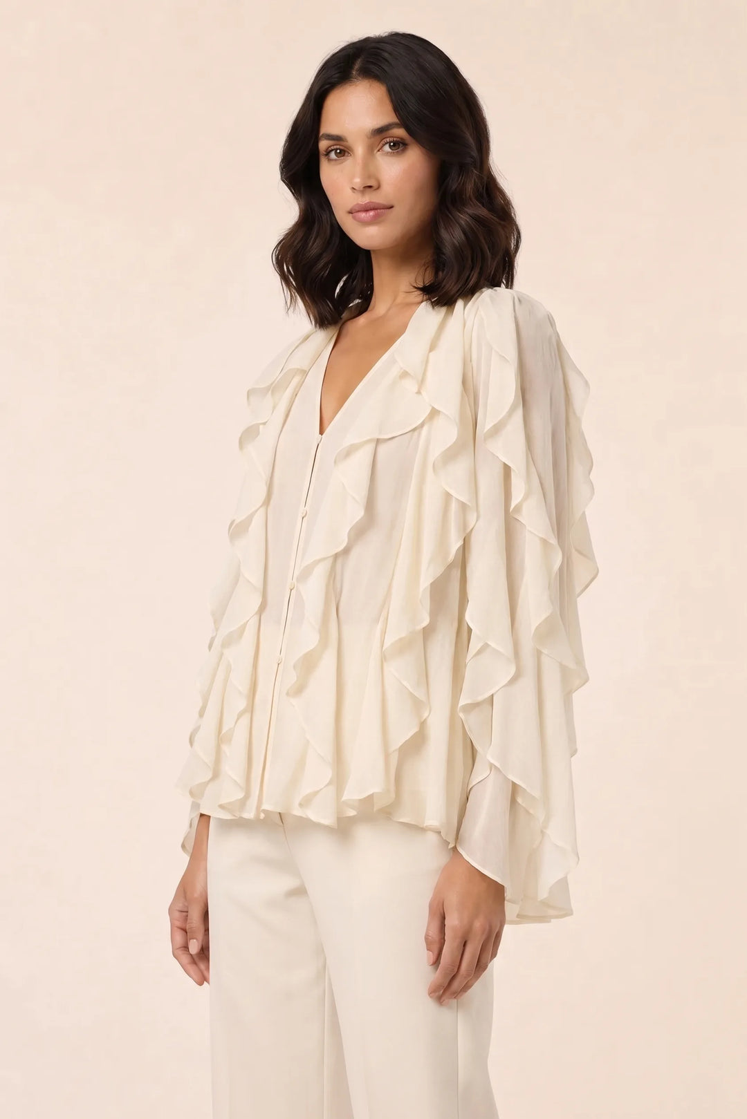 Yellow cascading ruffle blouse on a model in a three-quarter turn