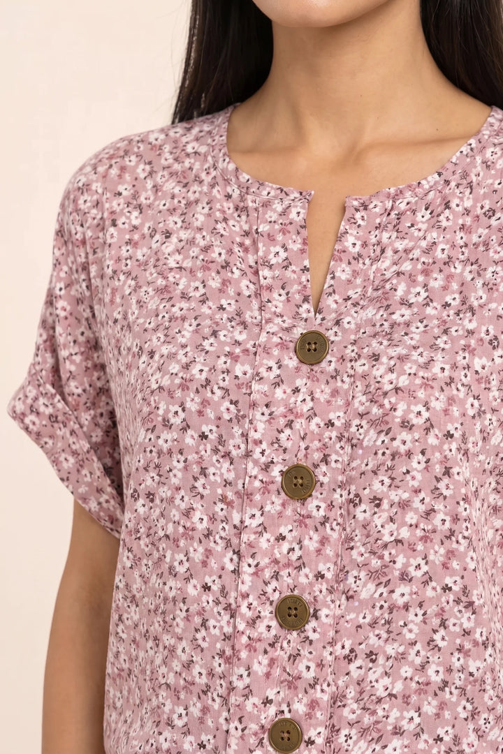 Close-up detail of pink ditsy floral button blouse fabric and buttons