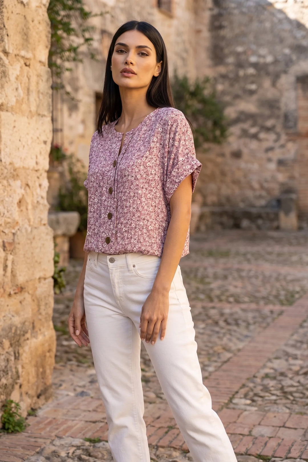 Model wearing pink ditsy floral button blouse in lifestyle setting