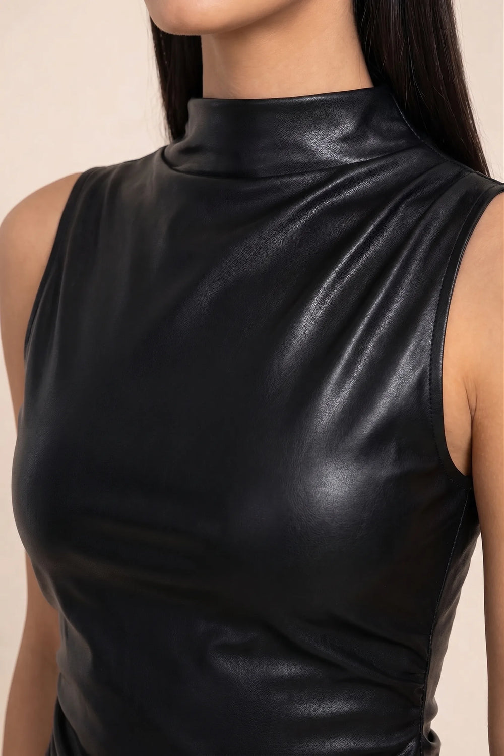 Close-up detail of black faux leather mock neck top