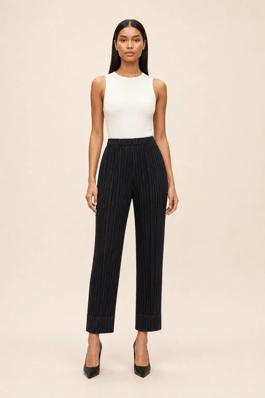Black pleated cropped pants on a model in a contrapposto stance