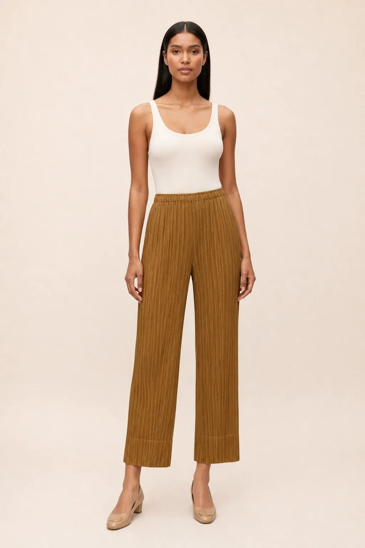 Caramel pleated cropped pants on a model in a contrapposto stance