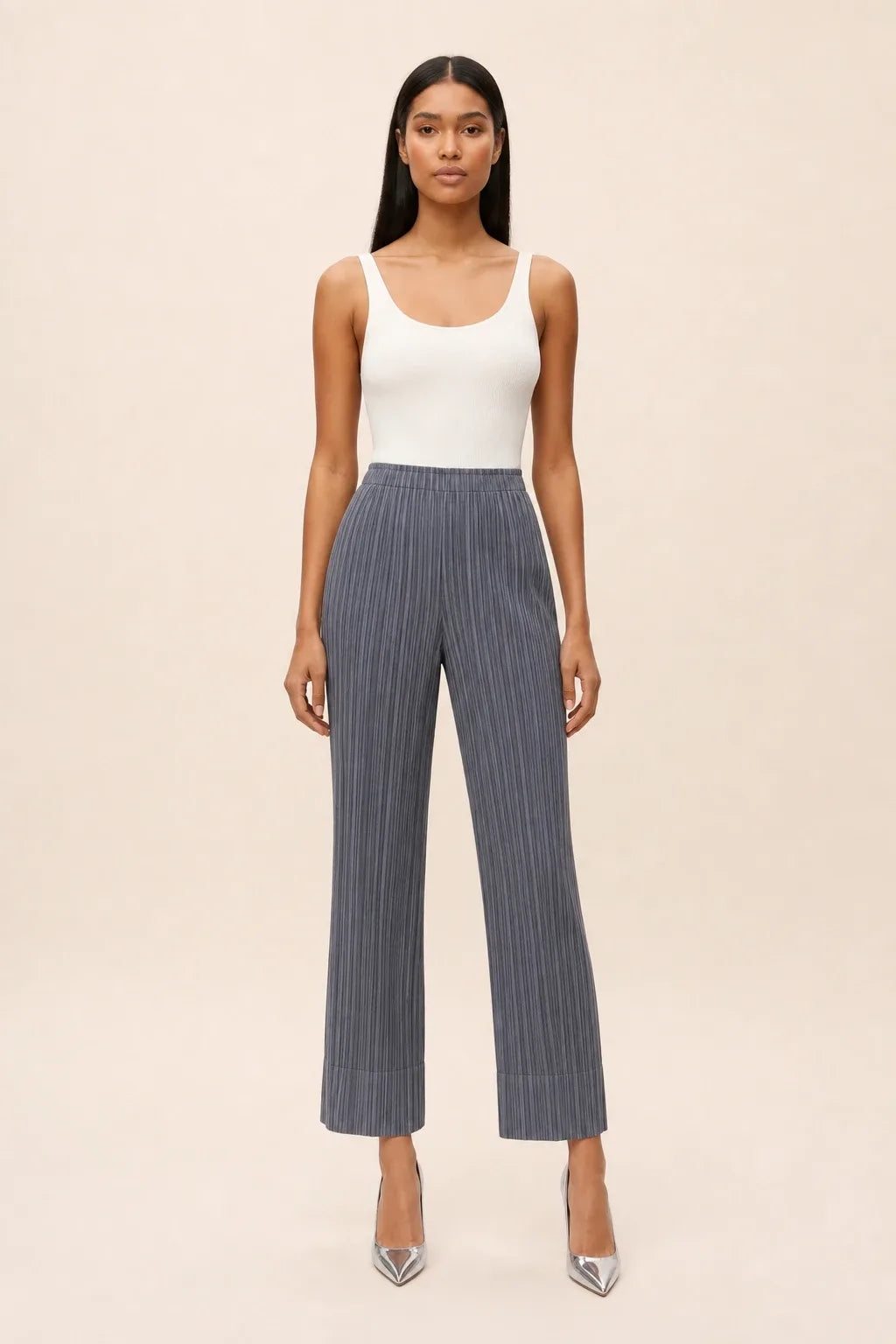 Gray pleated cropped pants on a model in a contrapposto stance