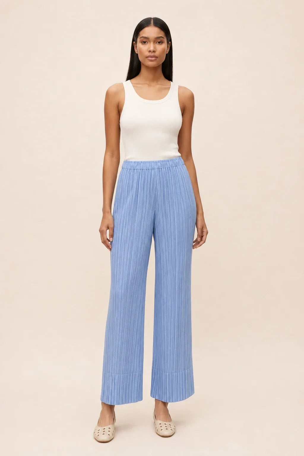 Sky blue pleated cropped pants on a model in a contrapposto stance