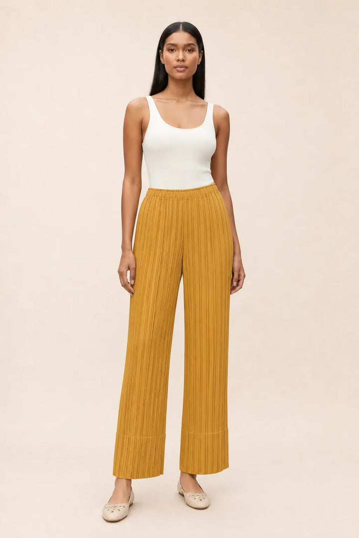 Yellow pleated cropped pants on a model in a contrapposto stance