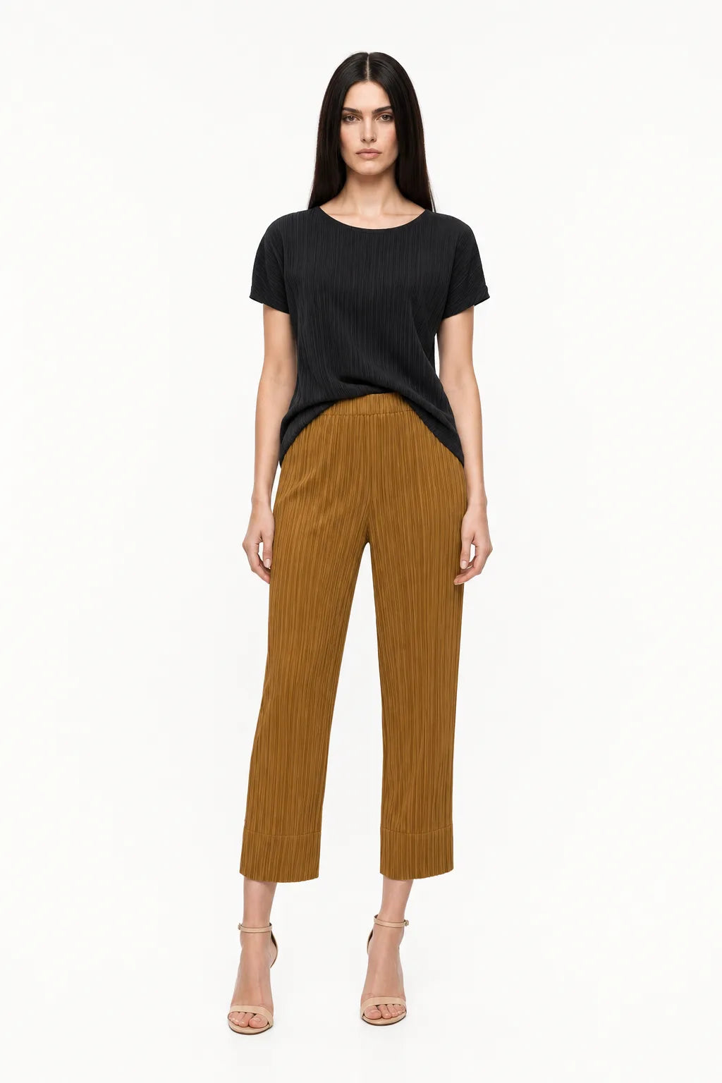 Caramel pleated cropped trousers on a model in a contrapposto stance