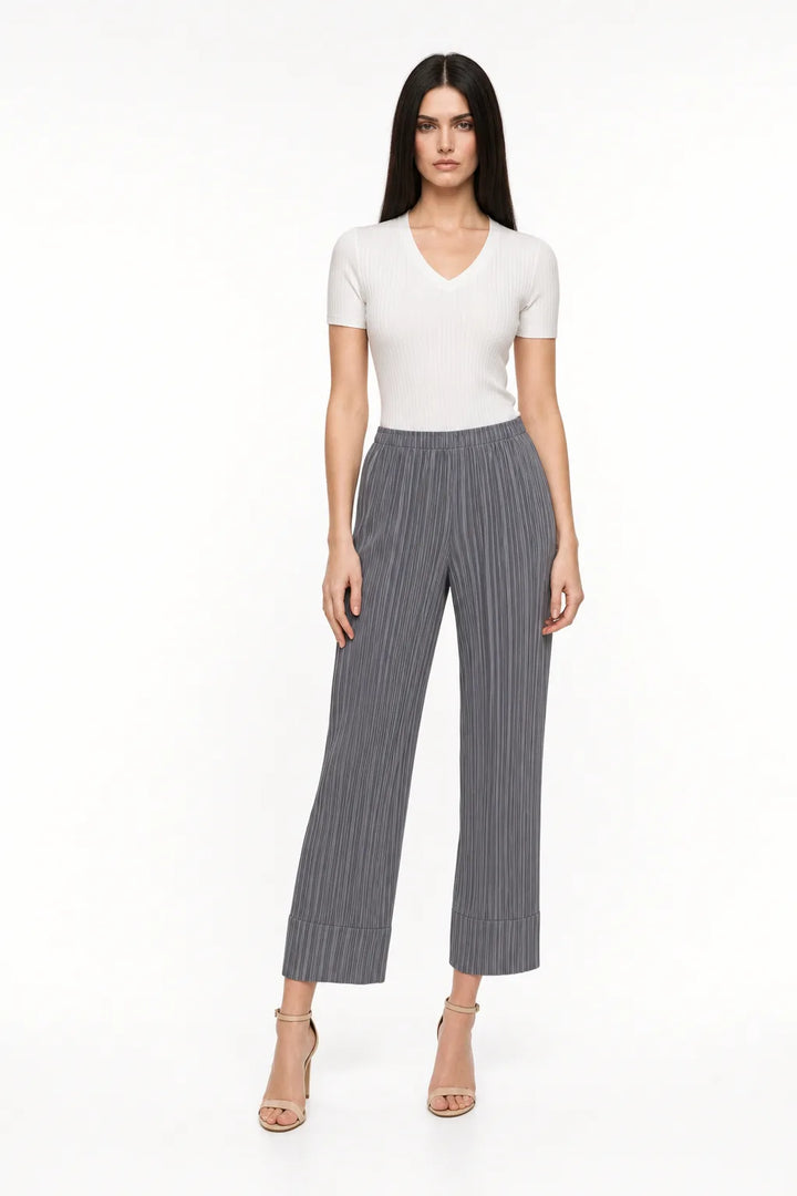 Gray pleated cropped trousers on a model in a contrapposto stance