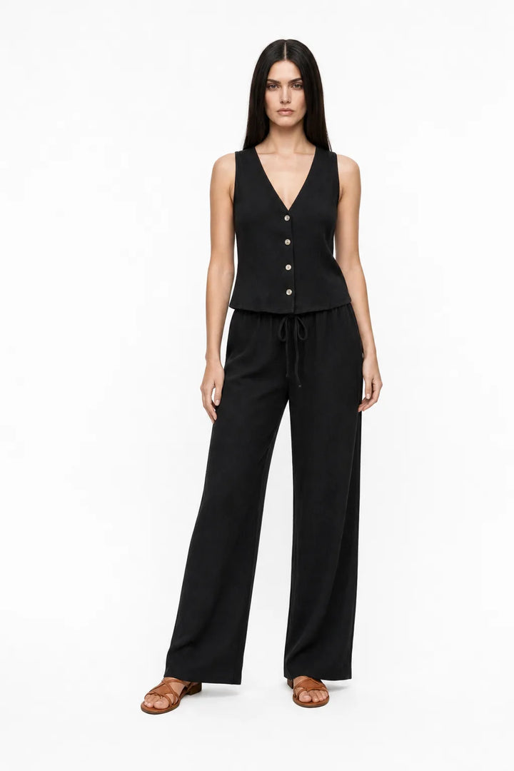 Black button-front vest and matching trousers on a model in a contrapposto stance