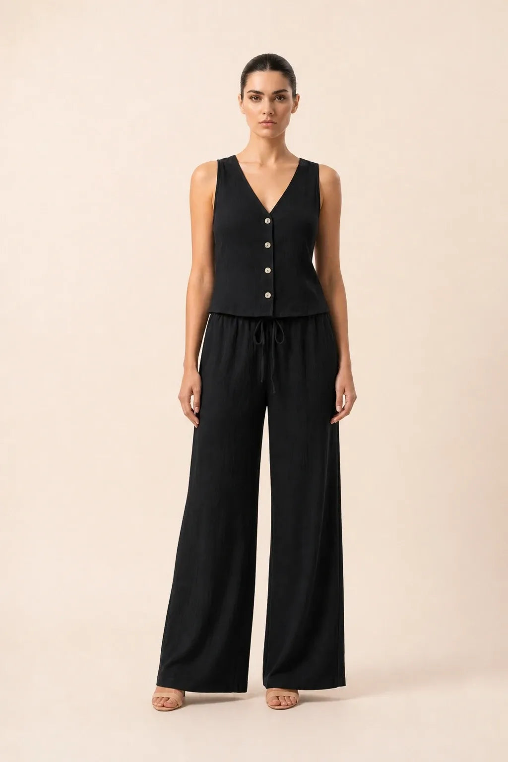 Black button-front vest and wide-leg trousers set on model in contrapposto stance