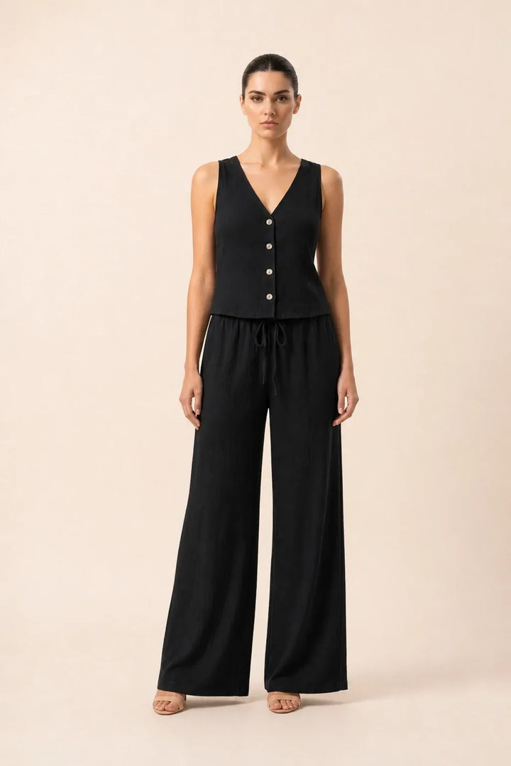 Black button-front vest and wide-leg trousers set on model in contrapposto stance