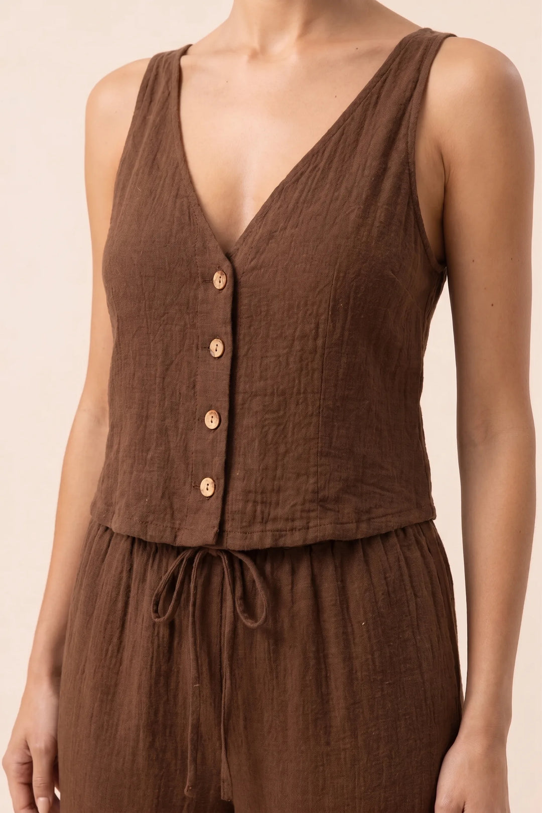 Close-up detail of brown button-front vest and wide-leg trousers set