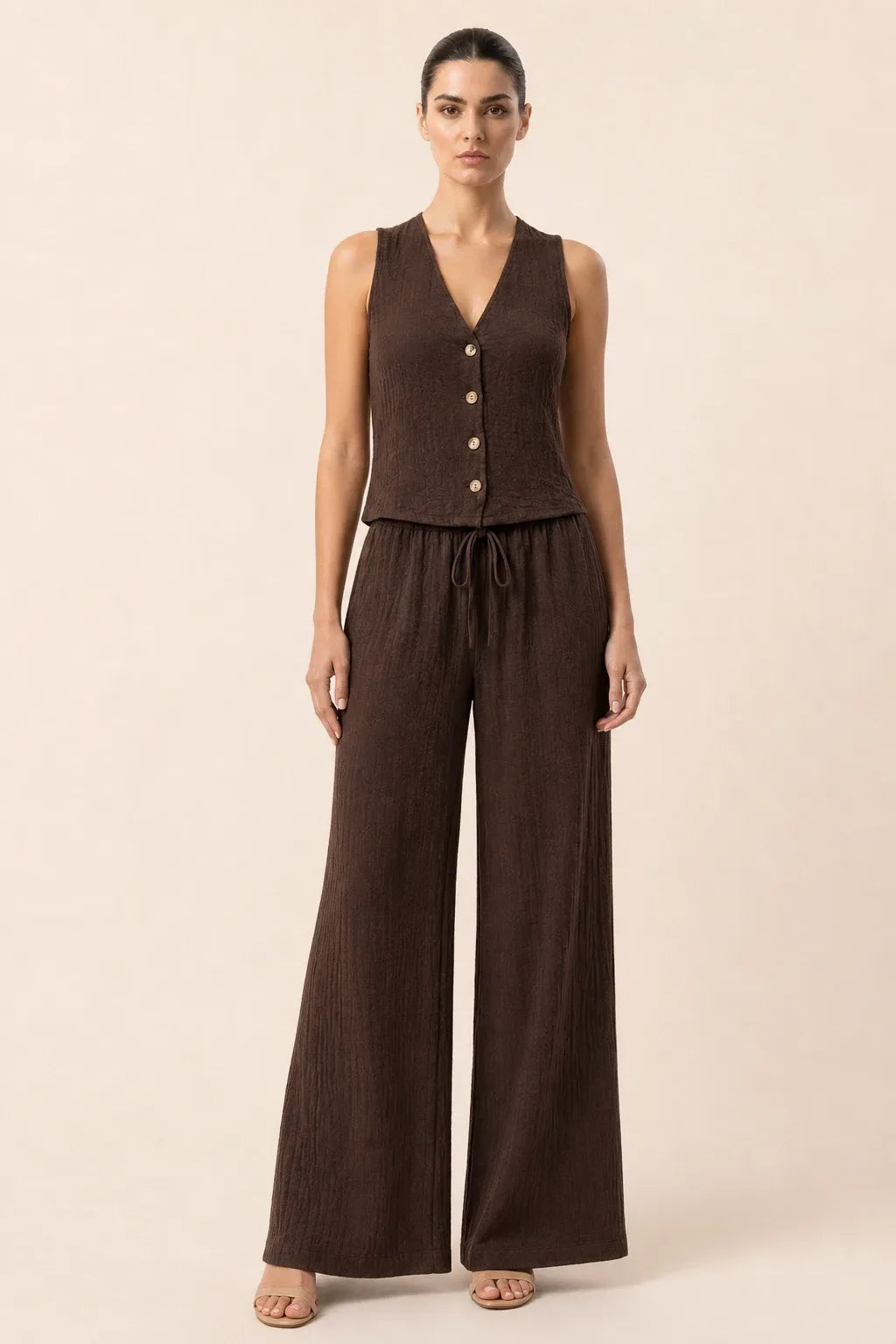 Coffee brown button-front vest and wide-leg trousers set on model in contrapposto stance