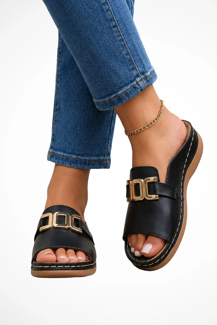 Black slide sandal with gold hardware accent strap, front view