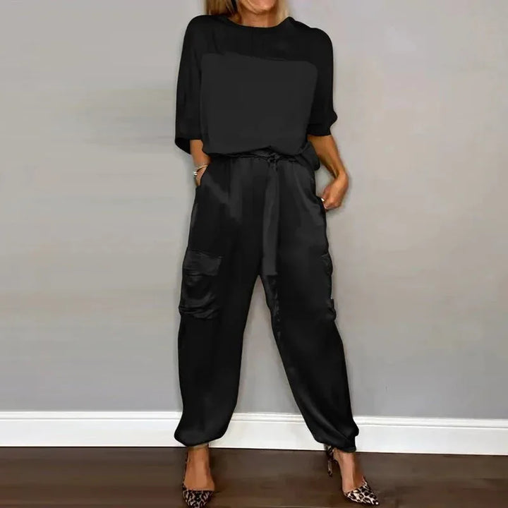 Side view of model in a black satin cargo jacket and matching wide-leg pants