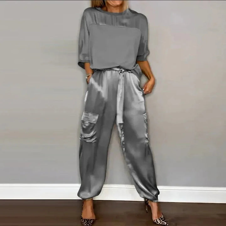 Close-up detail of grey satin cargo pants showing pocket and fabric texture