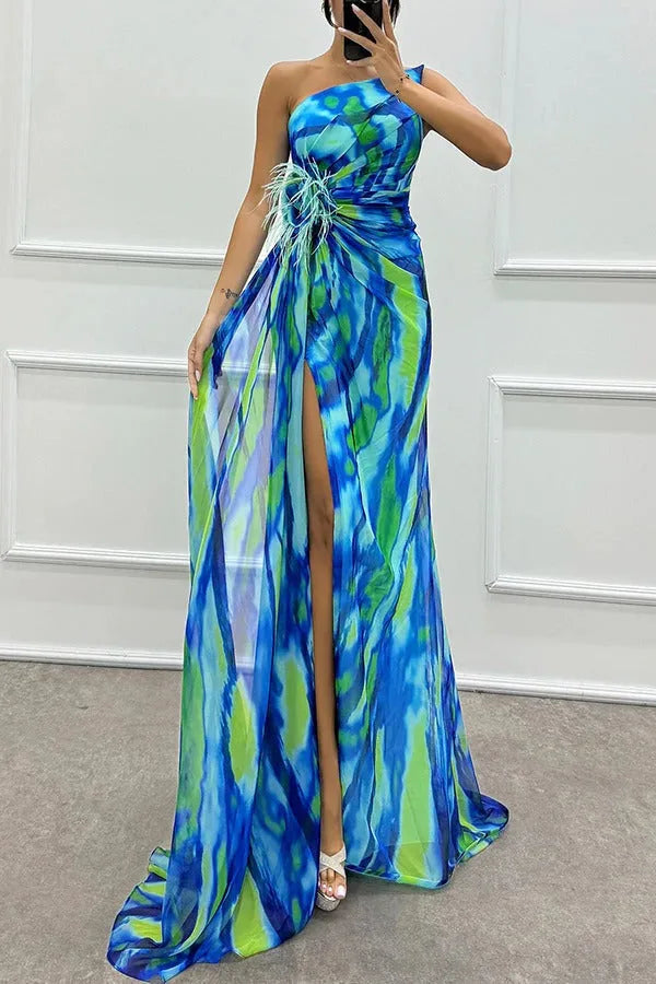 Model facing forward in a blue feather-trim maxi dress with floor-length skirt