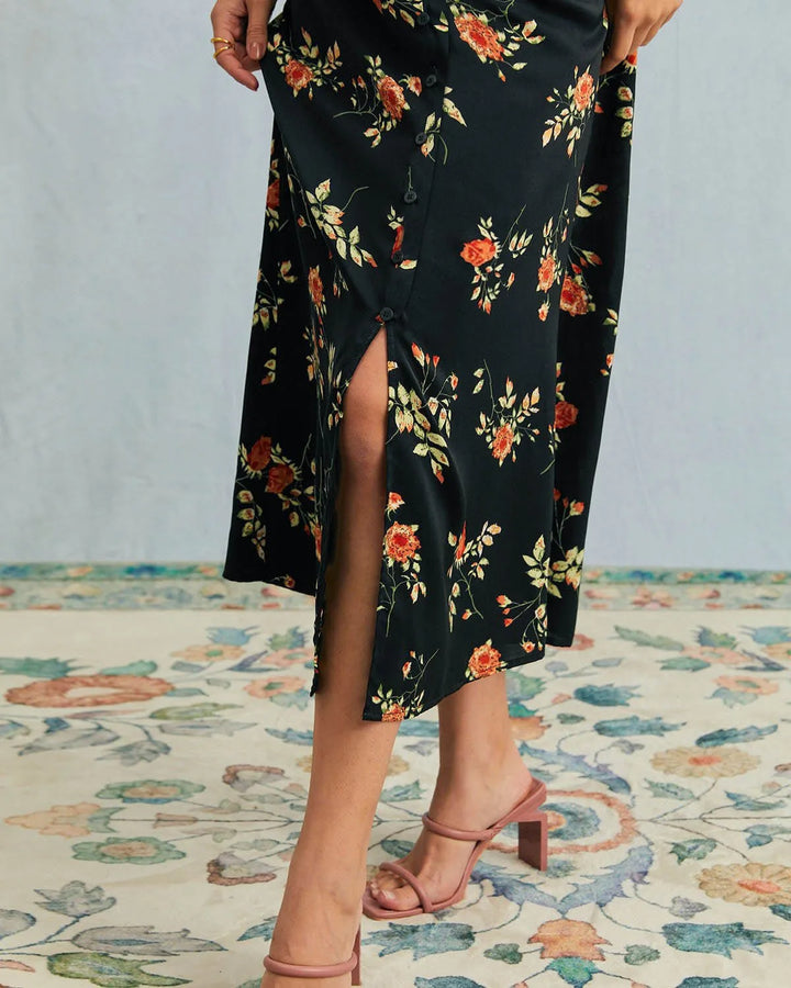 Model in side profile wearing a black floral maxi dress showing the length