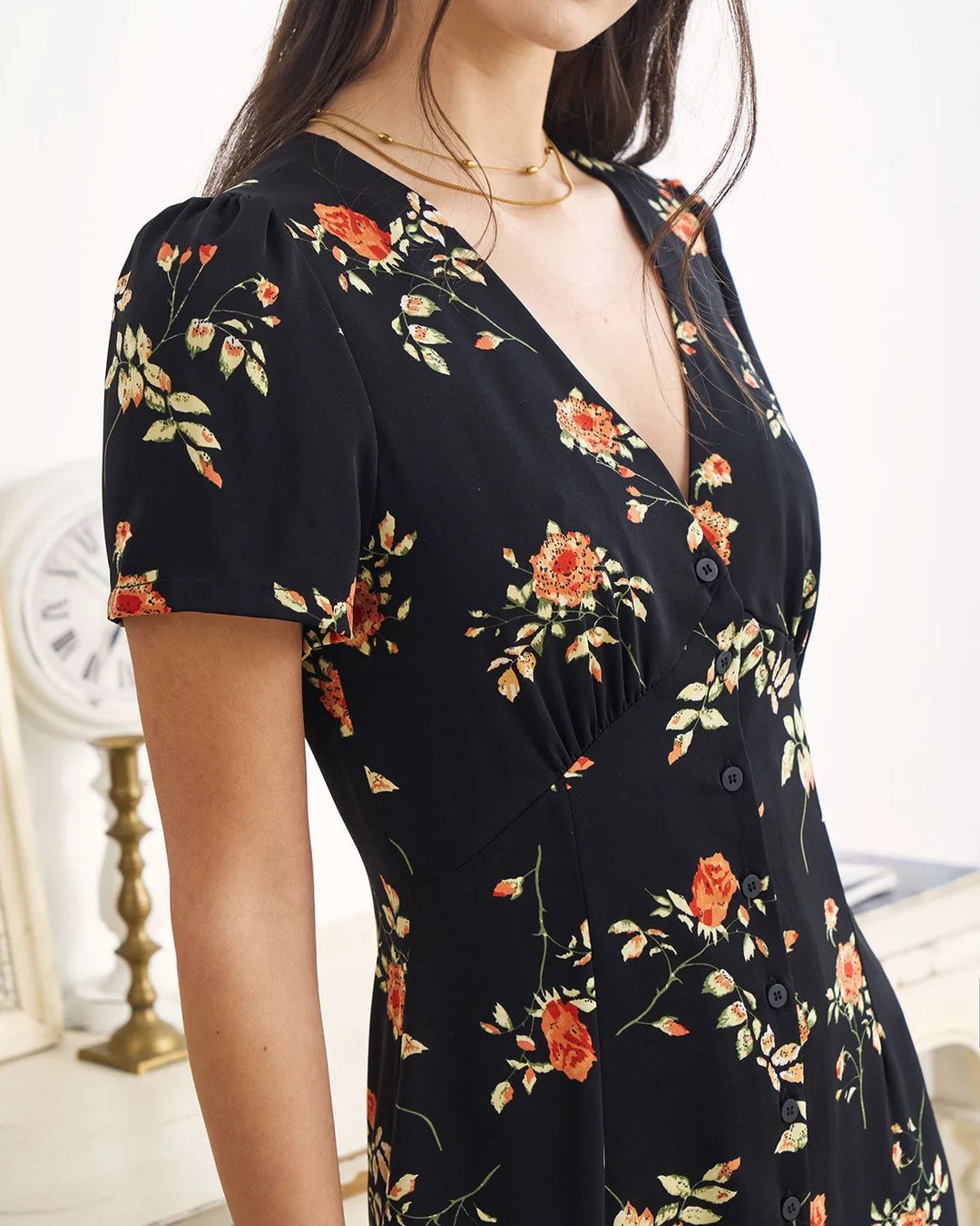 Model wearing a black floral maxi dress in a relaxed stance
