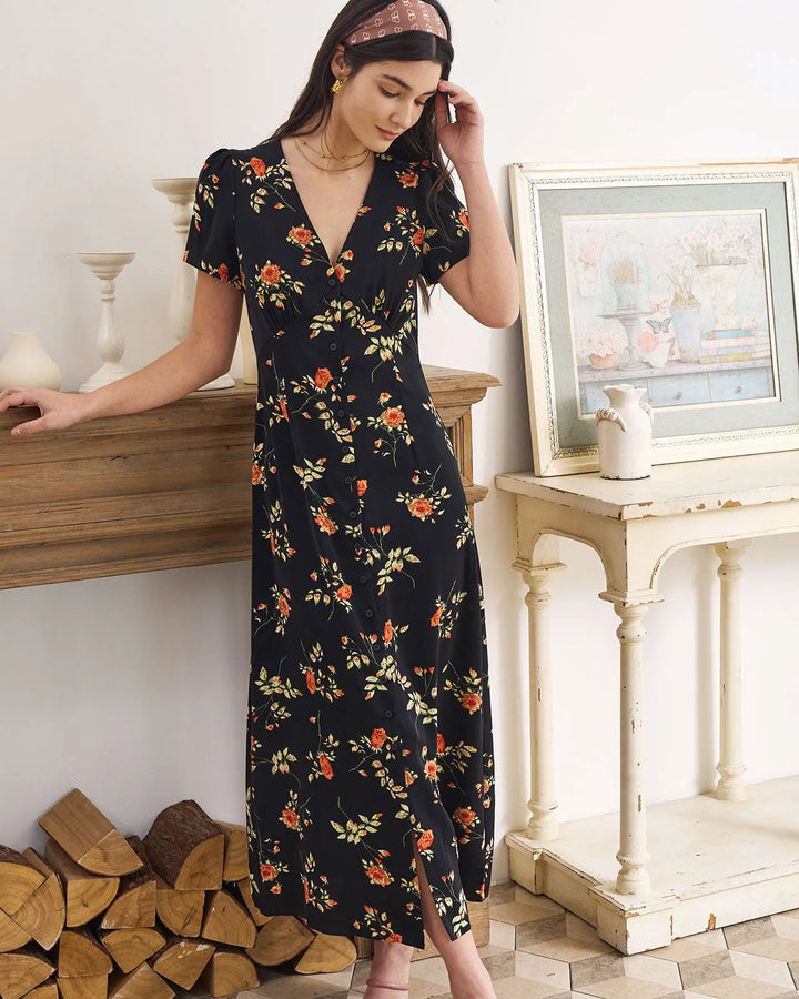 Model posing in a black floral maxi dress highlighting the fit
