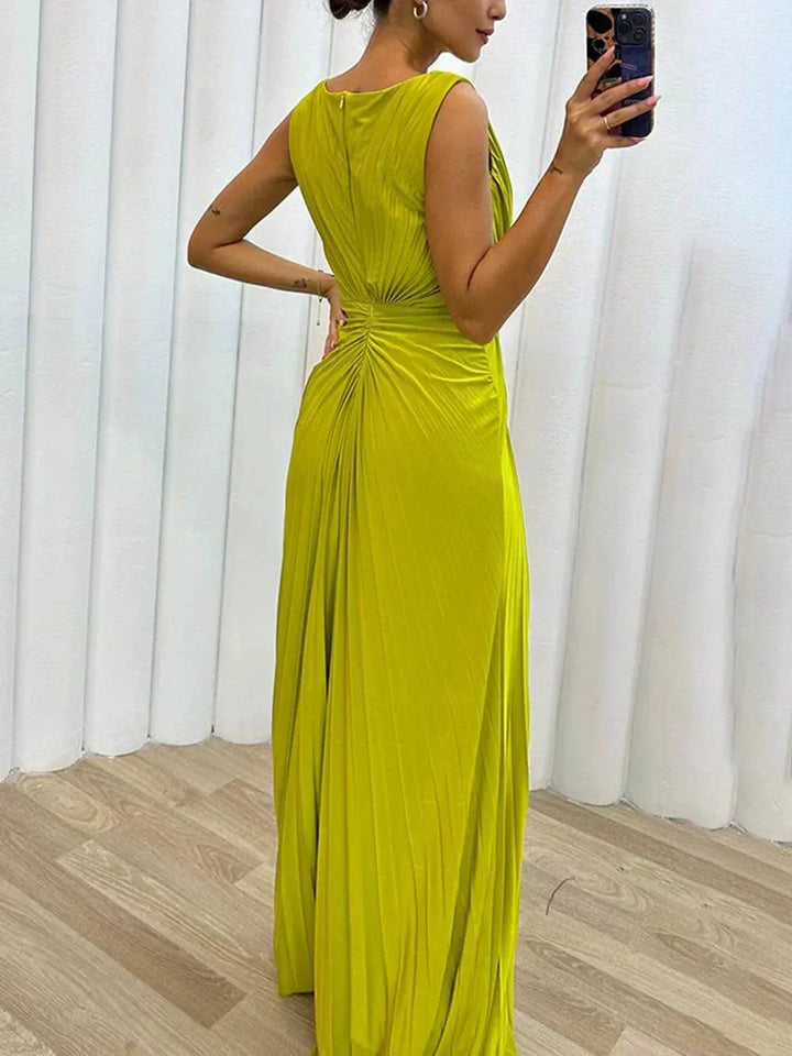 Close-up detail of a yellow pleated gown showing fabric texture and slit