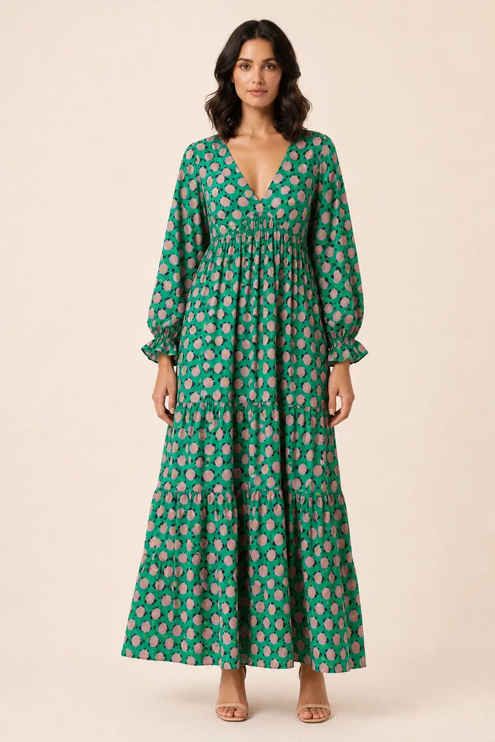 Woman in green floral tiered maxi dress, standing in contrapposto pose