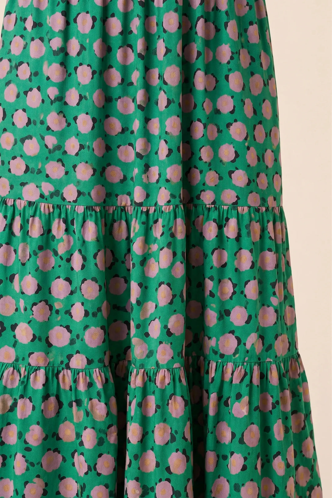Close-up detail of green floral tiered maxi dress fabric and tiers