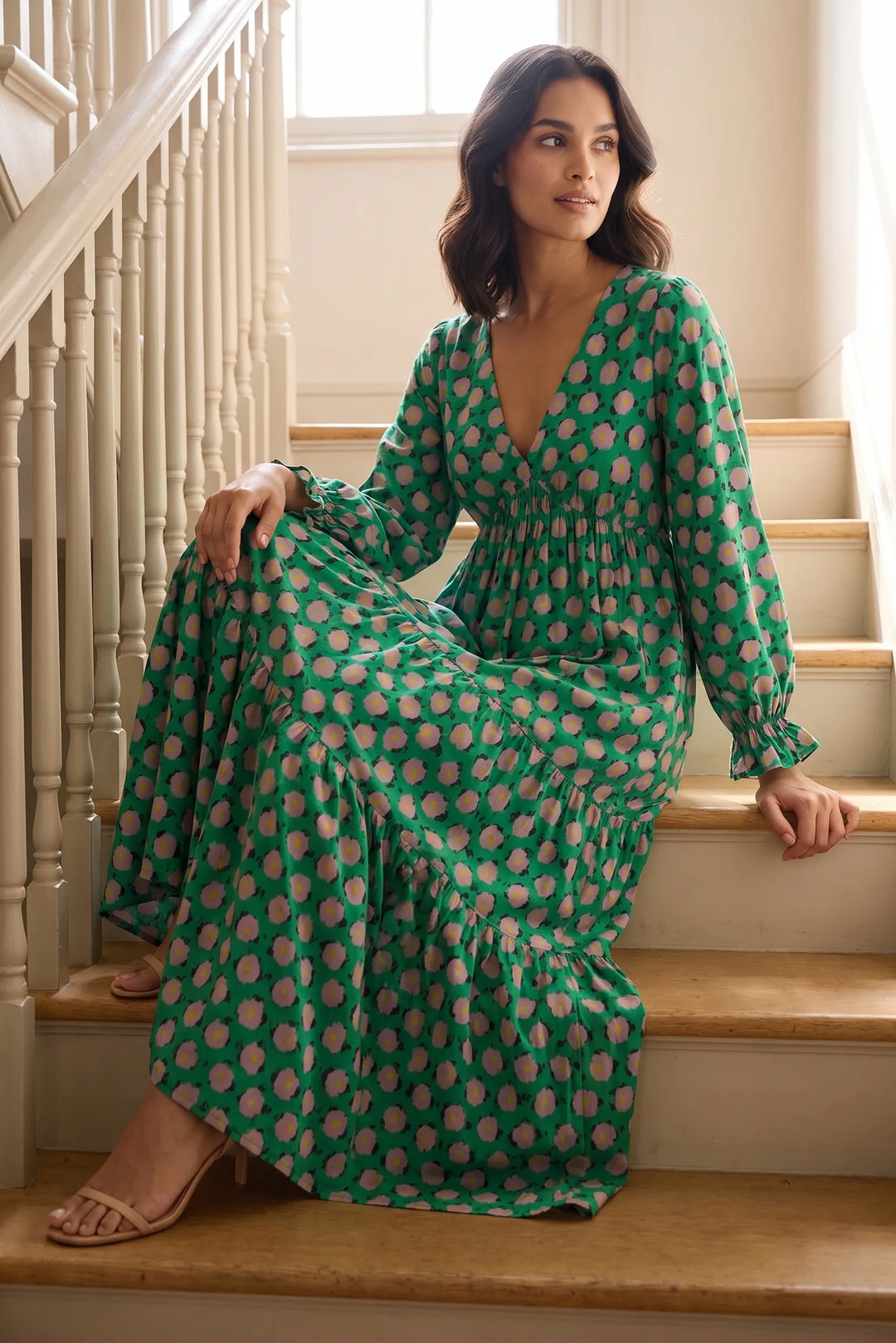 Woman in green floral tiered maxi dress in an outdoor lifestyle setting