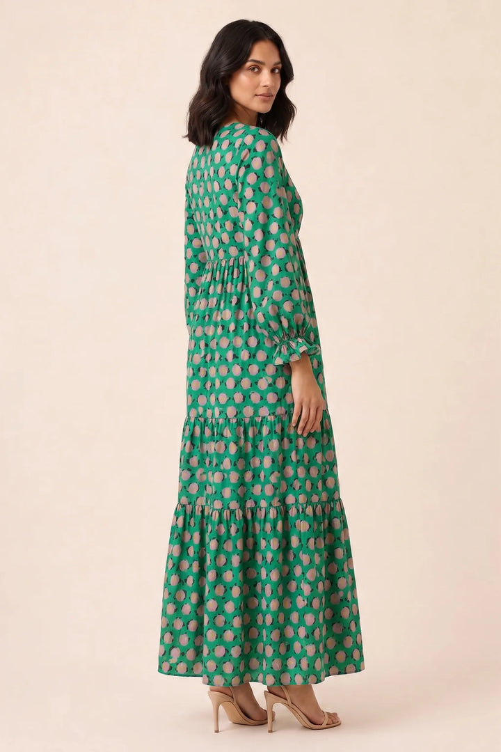 Woman in green floral tiered maxi dress, three-quarter turn view
