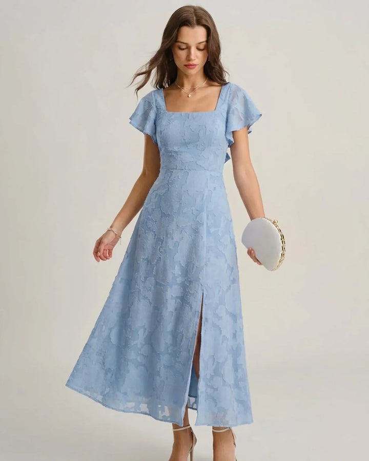 Woman in a blue flutter sleeve midi dress, turned at a three-quarter angle