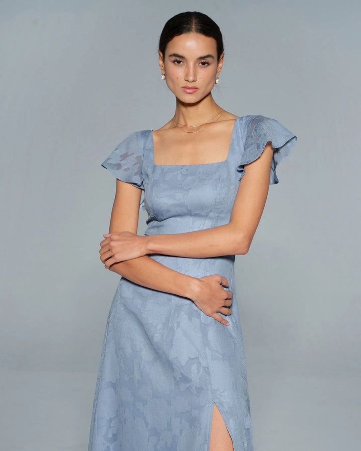 Woman in a blue flutter sleeve midi dress, alternate full-length view