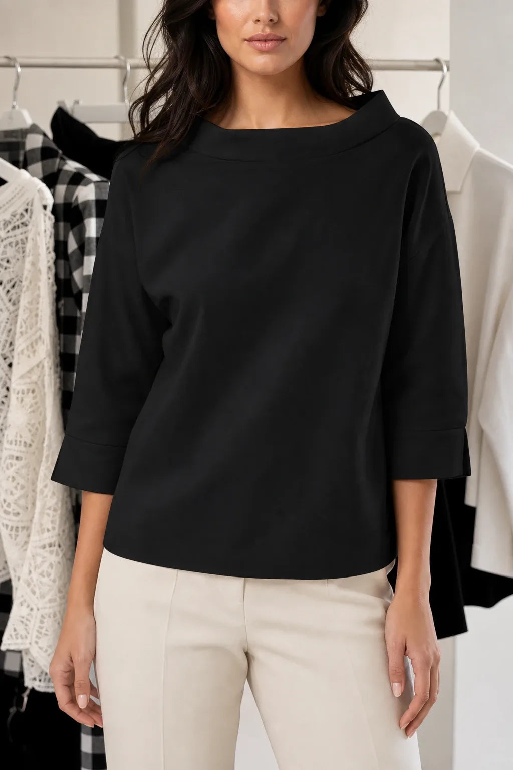 Black boat neck relaxed top on model in contrapposto stance