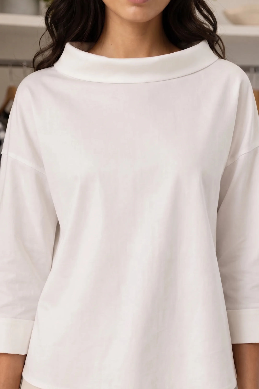 Close-up detail of white boat neck relaxed top fabric and neckline