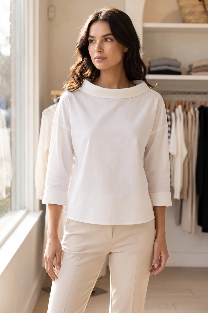 Model wearing white boat neck relaxed top in lifestyle setting